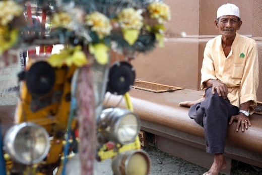 An old man awaits with his vehicle (Riksaw) in the outside of the market for possible clients.
Despite the mass use of motorized vehicles,many are the old men that still offer their traditional bikes for a few coins.
