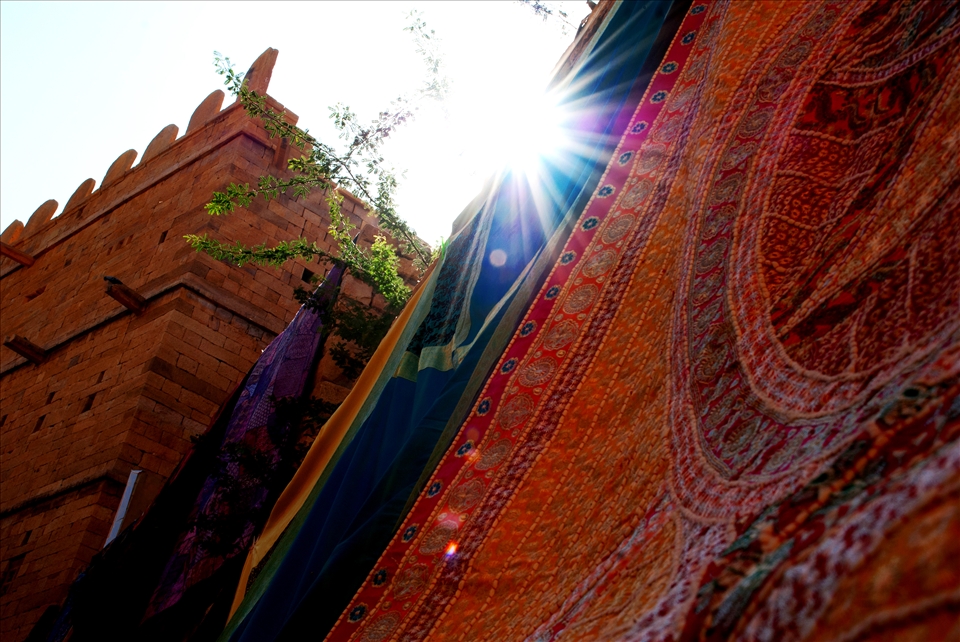 Tall walls of the historic forts covered with colorful handmade sheets.
