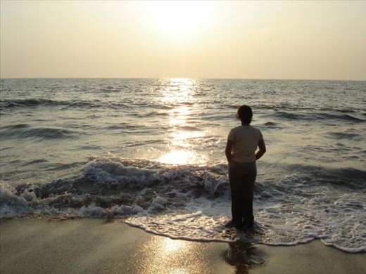 The serene and scenic beaches of Kerala are a major tourist attraction. In this picture, the calmness of the sea seems to have provided to the lady, a sense of solitude from the daily chaos of a country where more than a billion people reside