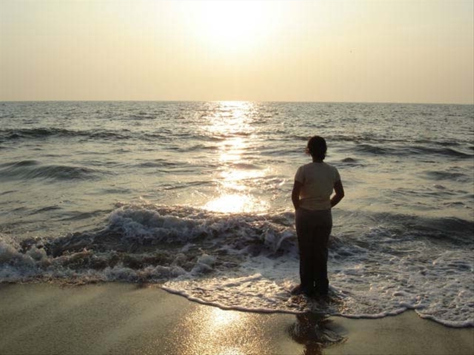 The serene and scenic beaches of Kerala are a major tourist attraction. In this picture, the calmness of the sea seems to have provided to the lady, a sense of solitude from the daily chaos of a country where more than a billion people reside
