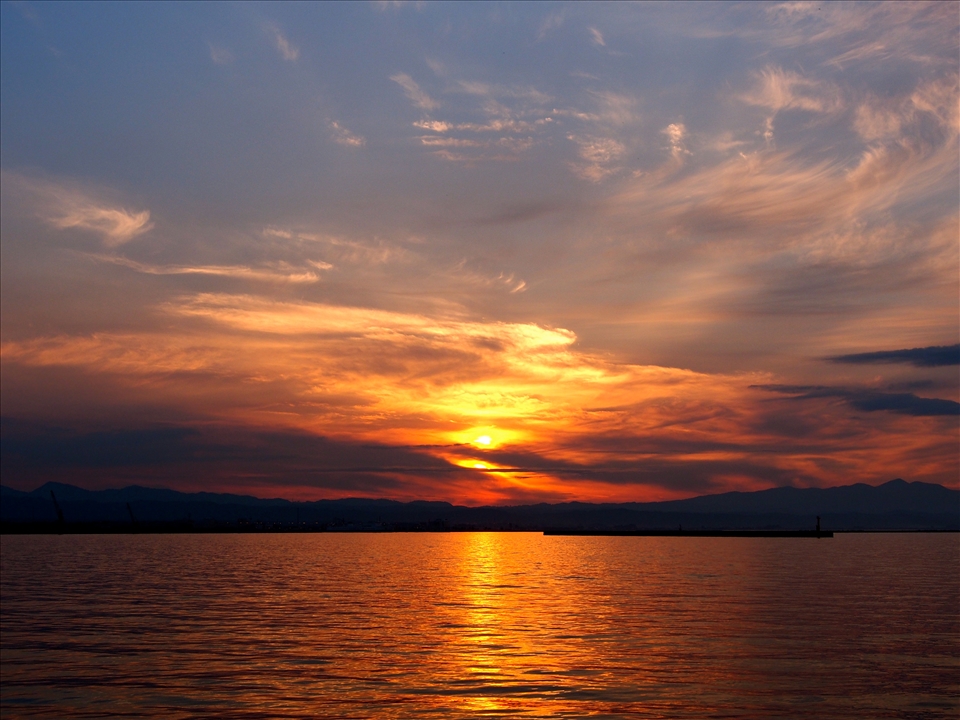 A palette of red, orange, gold, pink and purple merge with the flawless sky