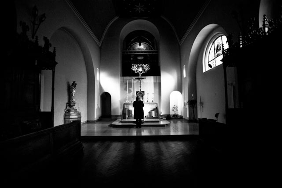 A lady deep in worship, alone, in a quiet moment at St Saviour's Chapel