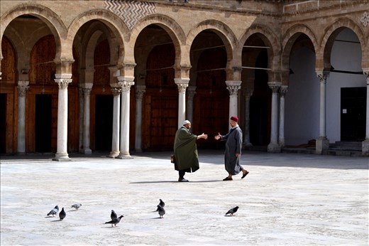 In the mosque, two men, they seem to know each other and are reaching out, a sig