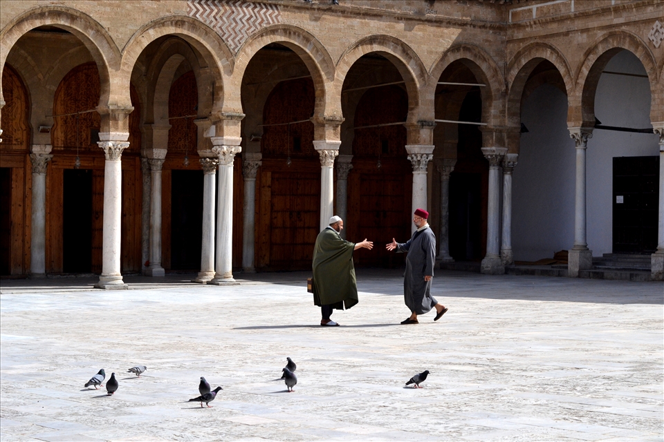In the mosque, two men, they seem to know each other and are reaching out, a sig