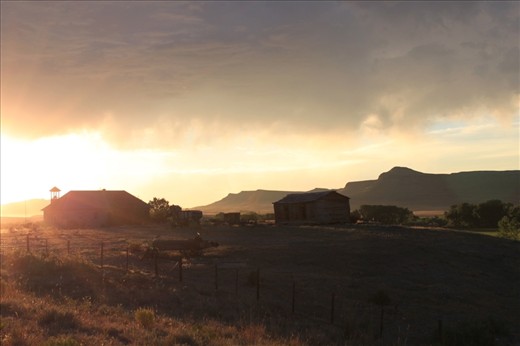 The sun sets after a seering hot day over an abandoned farm in Wyoming