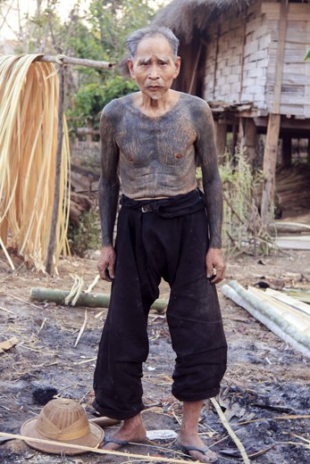 Pushia, an 86-year old retired wood collector stands in front of his hut wearing his traditional Shan pants. Now, the grandfather of 4 kids has been living in this small village since his birth and has never encountered a foreigner since the last British occupation after the Second World War. Living a life without electricity, phone or television is not a great concern for him, he only worries that the sun will never rise again, and the wood will seize to exist. He is proud of all his tattooed body which makes him feel more connected to nature.