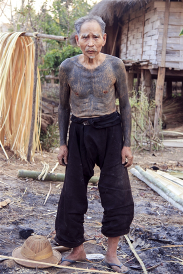 Pushia, an 86-year old retired wood collector stands in front of his hut wearing his traditional Shan pants. Now, the grandfather of 4 kids has been living in this small village since his birth and has never encountered a foreigner since the last British occupation after the Second World War. Living a life without electricity, phone or television is not a great concern for him, he only worries that the sun will never rise again, and the wood will seize to exist. He is proud of all his tattooed body which makes him feel more connected to nature.