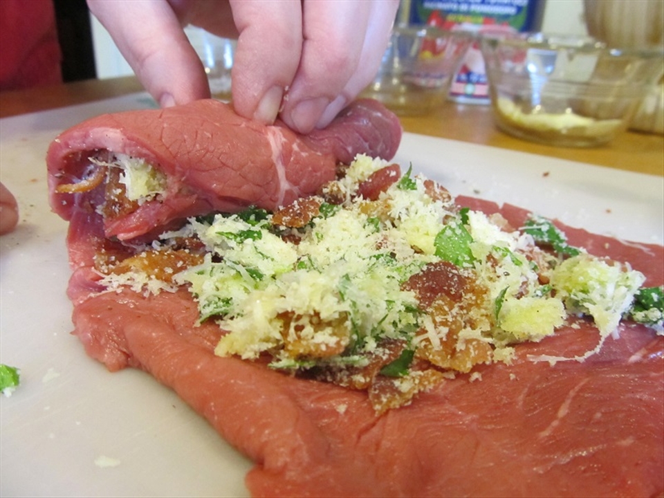 Rolling the braciole with filling.