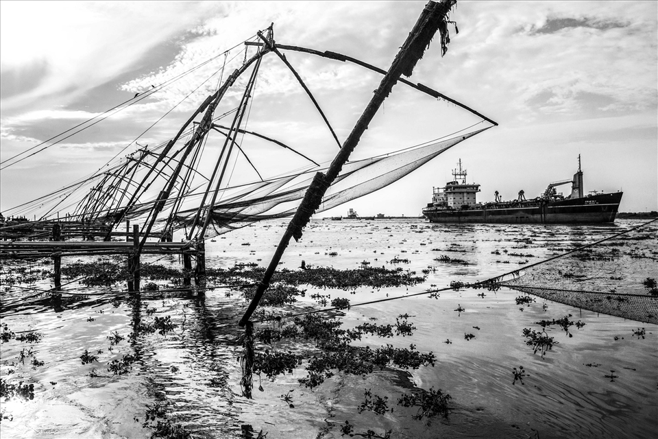 A passing contrast of modern seafare and dated fishing methods in Cochin, Kerala.  