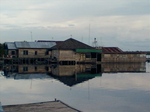 Sunny afternoon in floating houses, traditional houses of Palangkaraya, the capital city of Central Kalimantan, Indonesia. The shadow of house which is reflected by the river makes a modest home was appealing.