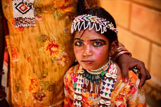 A mother, in Jaisalmer, is offering her young child, for a dollar or two, to be used as a model by the photographers that are roaming the fort.