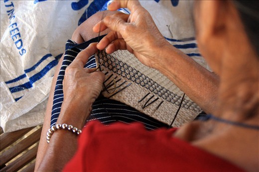 Baye Anna inserts nito(black vine) into a woven plate of buri to incorporate their patterns and designs. Baye Anna is considered one of the best and most learned among the Hanunuo Mangyans in terms of weaving baskets and fabric. 