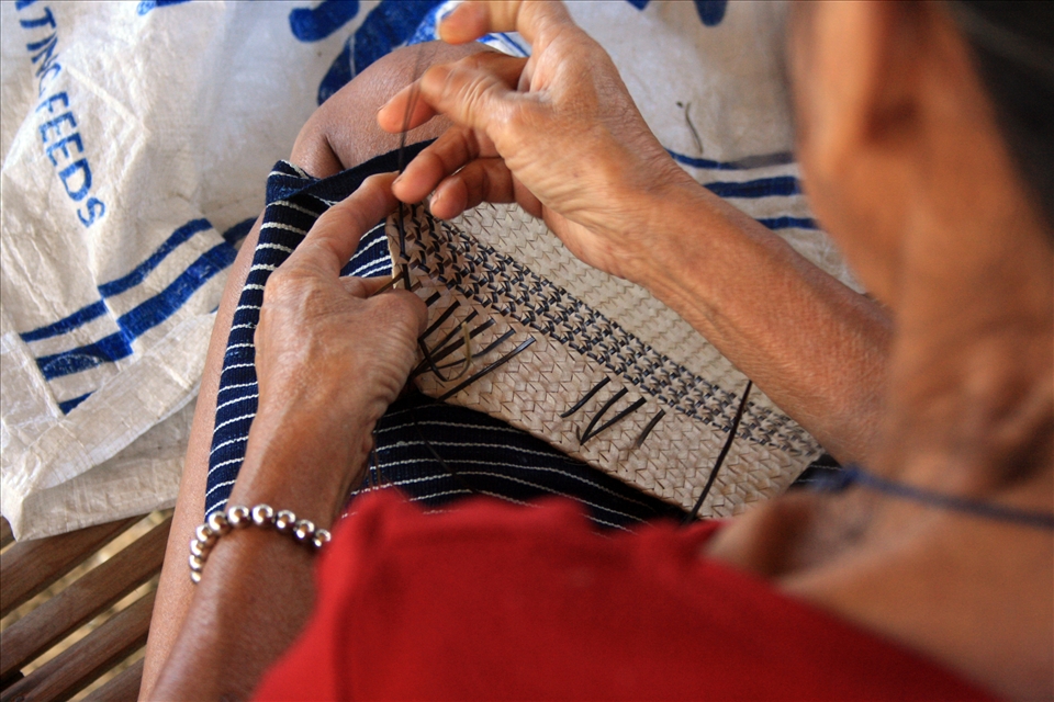 Baye Anna inserts nito(black vine) into a woven plate of buri to incorporate their patterns and designs. Baye Anna is considered one of the best and most learned among the Hanunuo Mangyans in terms of weaving baskets and fabric. 
