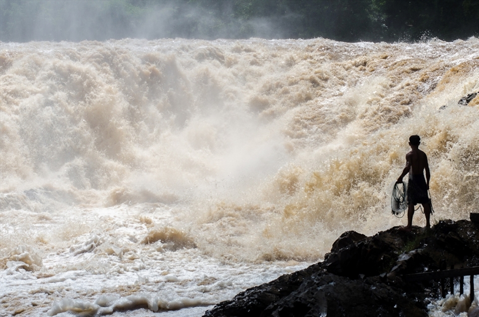 A brave fisherman stares into the wall of water at Khone Phapheng falls before casting his net into the ferocious current. During the rainy season the Mekong river swells rapidly causing millions of litres of water to crash over the falls each second. The highest flow ever recorded at Khone Phapheng falls was 49,000,000 litres a second. A select few fishermen risk their lives daily to carve out a living fishing these waters.