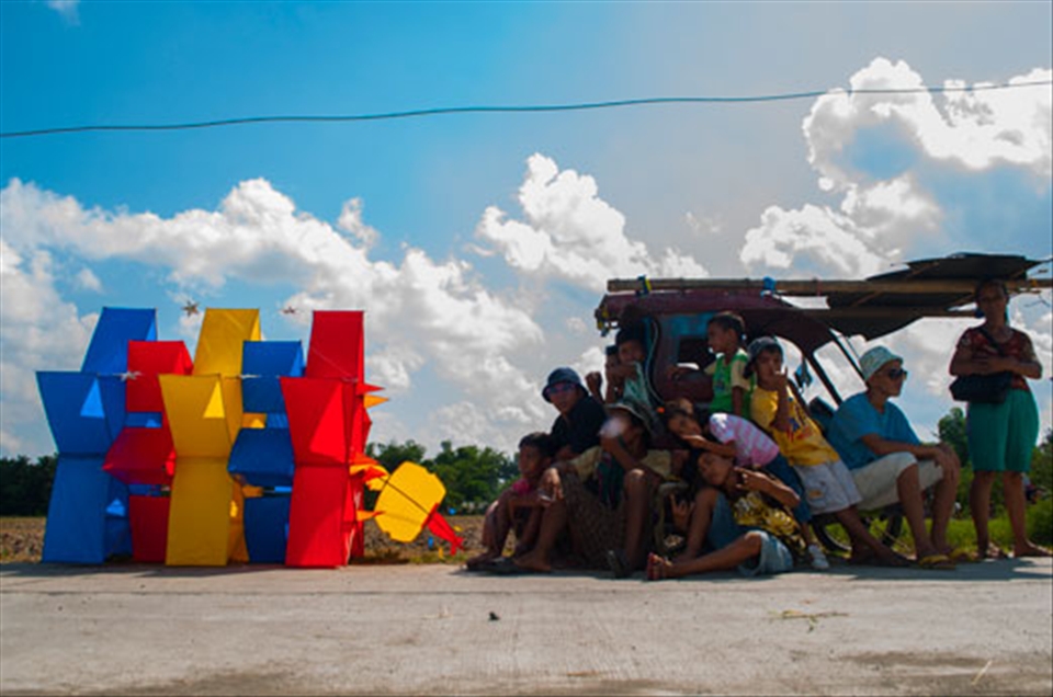 1.	The Kite Flyers. Every summer, one of the most popular activities among Filipino families is kite flying. It is often enjoyed with a group of people, and has been passed on through generations. Today, while the design of kites has become complicated, the nature of kite flying has remained the same, which is to bond people together, especially during school vacation. In the picture, a group of kite flyers were on a tricycle while waiting for a good wind. The tricycle is a motorcycle with a sidecar. This picture was taken in Jaro in Iloilo City.