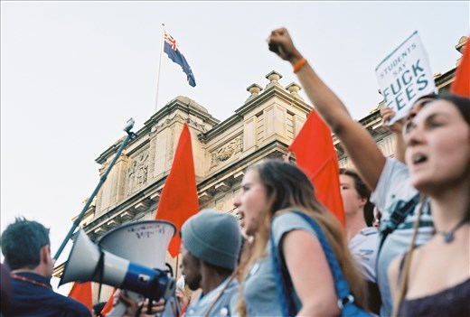 An Australian flag fly's high above the protestors