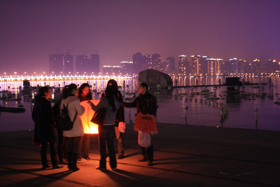 A group of Chinese friends releasing a lantern to remember a passing friend at Jin Ji lake in Suzhou.
