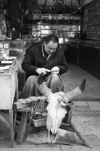 A Chinese artisan working a piece of bone into a comb for a tourist market in the outskirts of Suzhou