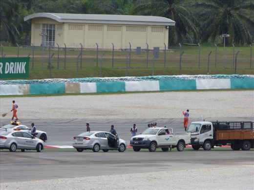 Race officials inspect the kerb after Grosjean's accident