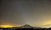 As night falls, city lights illuminate Mt. Rainier as stars tower above.: by jeff_abel, Views[427]