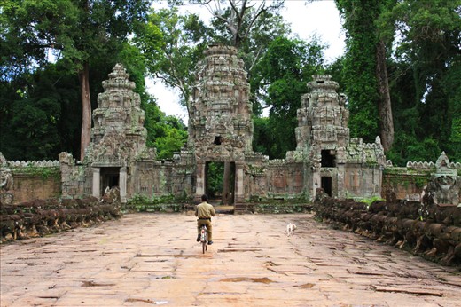 Roaming around the area with his companion dog, a man in uniform guarded the gate of one of the many Khmer temples in Angkor Archaeological Park.
