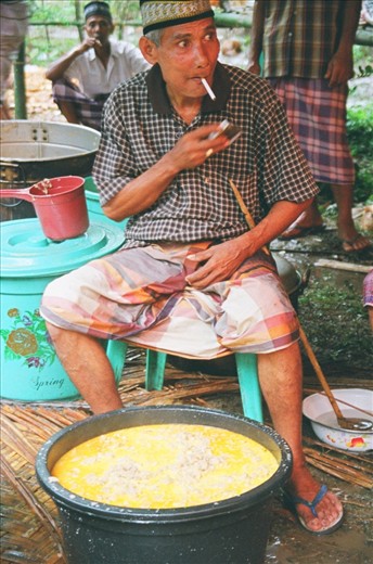 A local villager prepares food for the feast that will feed the whole village.  Cows were slaughtered out back and baskets of rice were prepared.  I found myself in the prep line at one point and was passing plates out to feed the 500 people that comprise the village.