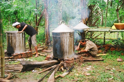 Back behind the celebrations men prepare curry in vats for the wedding feast.