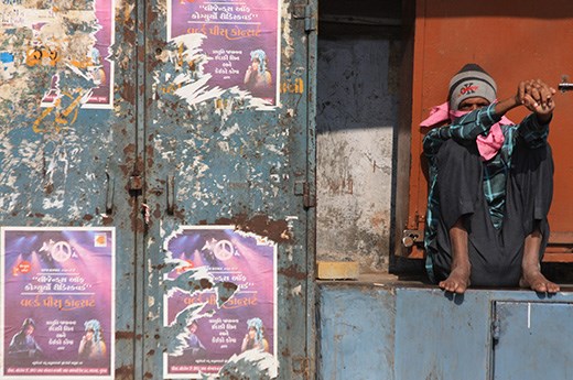 A man enjoys the sun, but not the dust, in Junaghad.  