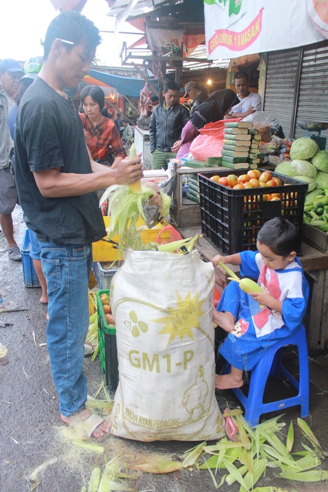 Cute boy was helping his dad peeling the corn husks with his small hands. The corn silks fell all over his clothes, and sometimes in a very cute way he asks his dad how to get rid of the silk. When I approached him, he was not really bothered by my existence, he kept focus on what he’s doing though his dad and brother kept teasing him to make him look to my camera.