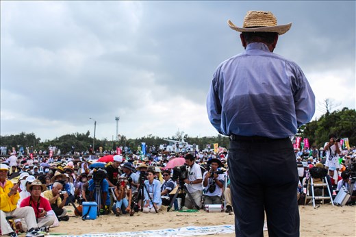 An activist outside the construction site of a new U.S. military base addresses a crowd of over 5,000 protesters. Okinawa is Japan's southernmost prefecture and although it only makes up 0.6% of Japan`s total land mass it houses 75% of the country's U.S. military base presence. The newest base is currently under construction in Henoko, Northern Okinawa, as part of a relocation deal to close down the controversial Futenma Air Station in the densely populated Ginowan City. However, many Okinawans are opposed to the plan and want the base moved out of the prefecture altogether. Mr. Onaga, a strong opponent of the relocation plan won the recent prefectural elections by a significant margin campaigning on an anti-base platform. 