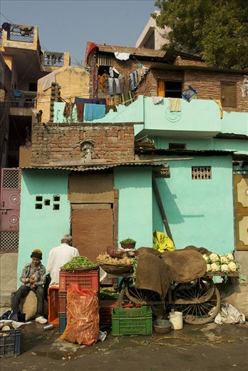 A father and son slowly prepare the family vegetable stand for the day, just below their home along the railway. 
