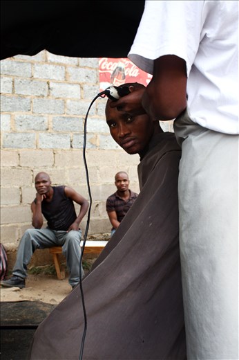  As the barber sterilizes his shears in turpentine, jobless men start to gather