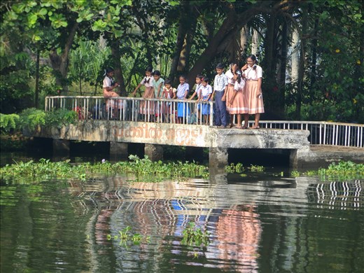 Girls stand together with boys, waiting for the morning school boat in Alleppey.