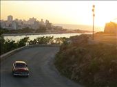 A View to the Past: Havana is a city of many contradictions. Yet, when you travel there is feels as if you are suddenly transported back in time to the 50's, surrounded by old American cars and crumbling buildings. This picture signifies the old world feeling of the city, combining both the old cars and the old city in the background. The golden glow from the sun setting makes it looks at if the photo is as old as everything in it. The picture was taken from the Christ Statue on the hill above Casablanca across Havana Harbour from the city. : by jetsettingadventurer, Views[443]
