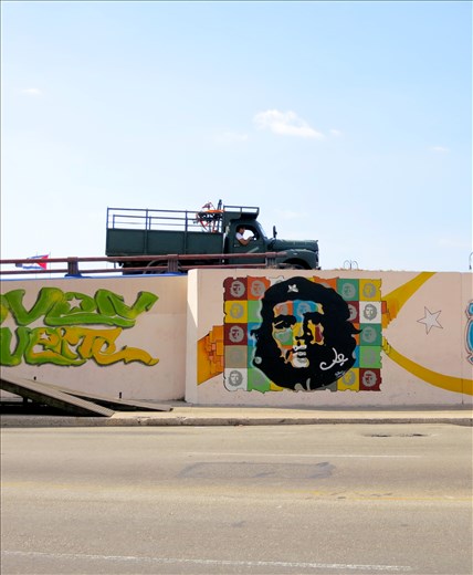 Revolutionary Spirit:
On every street corner and building there is evidence of the 1959 Socialist Revolution. This graffiti of Che Guevara (Revolutionary Leader) is one of the most iconic images of the revolution and is found all over the city, this particular image was taken in the old city on the median of a busy city street. It's both evidence of the collective past that Cubans have shared but also signifies the small piece of revolutionary each Cuban carries around with them. I think that the truck in the image represents Cubans carrying on with their lives amongst the memory of their incredible history. 