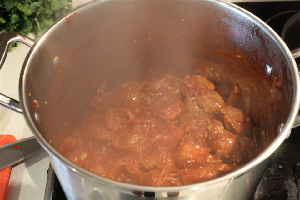 Browning the lamb with tomato and spices