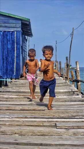 Two boys, running down a jetty in Semporna, Malaysia - just finished school.