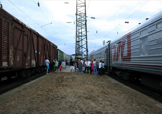 Passengers stretching their legs and chatting in the Summer heat of Russia after the train has made one of the few stops during the day.
