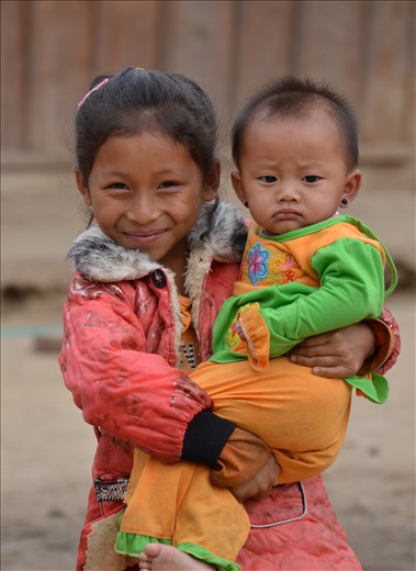 This beautiful little girl so badly wanted to get her photo taken. She was torn between looking after her little brother who was crying and wanting to pose for the camera.

In so many remote villages like this one we came across hiking between ziplines, children are responsible for their younger siblings at such a young age. This little girl wouldn't have been any older than 8 or 9, yet with the responsibilities of an adult. 