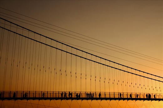 Pilgrims using the Laxman Jhula to cross over the river Ganges. It is believed that Lakshman, brother of the Hindu god Ram, crossed the river using jute ropes at the place where this bridge is now built.