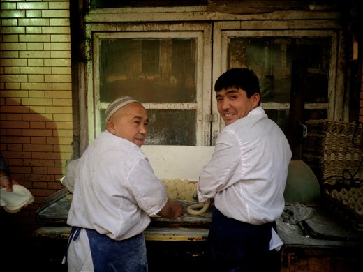 Bakers merrily prepare dough for Munti at Kasghar's central market.
