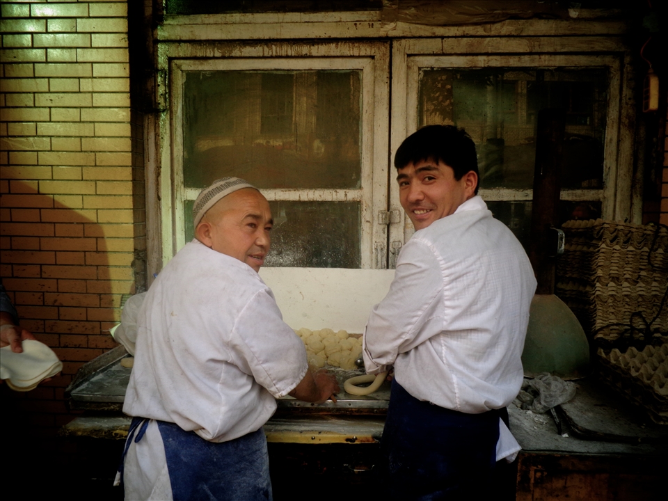 Bakers merrily prepare dough for Munti at Kasghar's central market.