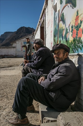 One of seven old men sitting in a village really doing nothing at all. 