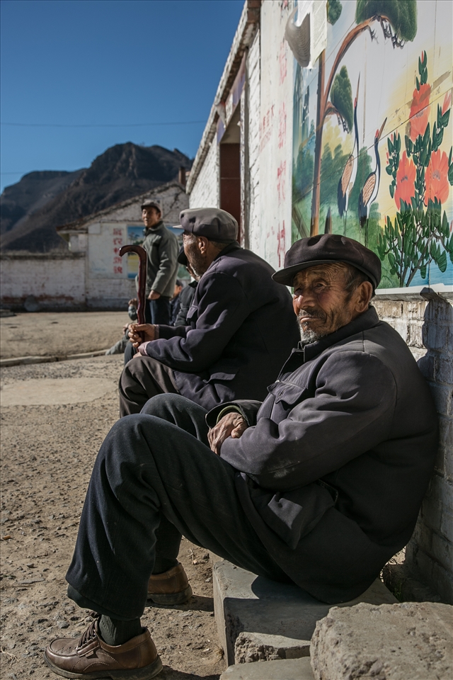 One of seven old men sitting in a village really doing nothing at all. 