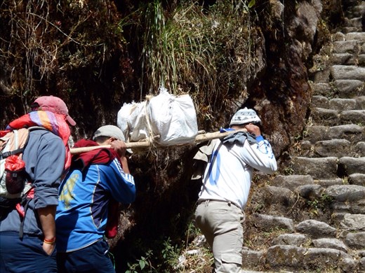 Locals carrying batteries for the local communication system. Each box weighed 60kgs