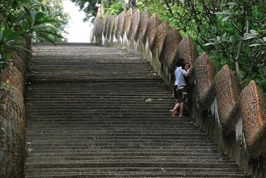 Two local girls shy from the camera on their way up to Wat Phra That