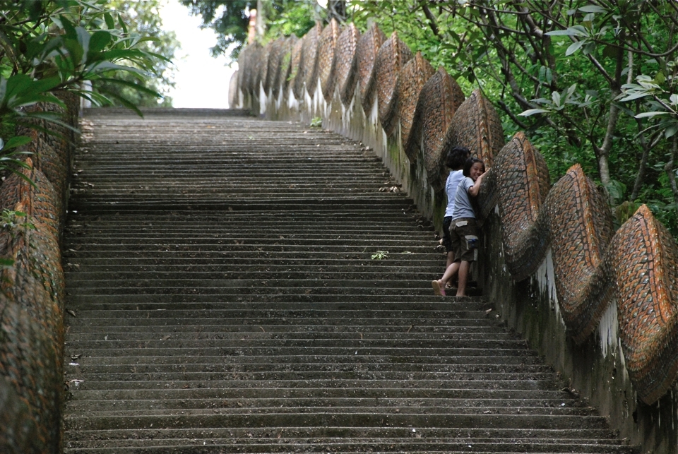 Two local girls shy from the camera on their way up to Wat Phra That