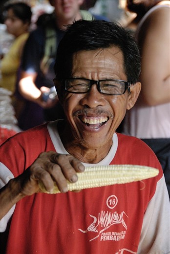 A corn seller laughs heartily, at what I still don't know, just happy with life.  