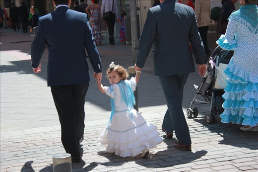 A young Sevillan girl follows her uncles to the fair grounds. Even the youngest wear classic flamenco dresses to celebrate the festival which dates back to 1847. Fería started as a livestock fair, but eventually transformed into the spectacular celebration that can be seen today.
