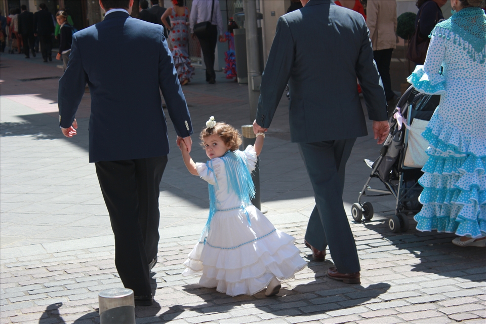 A young Sevillan girl follows her uncles to the fair grounds. Even the youngest wear classic flamenco dresses to celebrate the festival which dates back to 1847. Fería started as a livestock fair, but eventually transformed into the spectacular celebration that can be seen today.